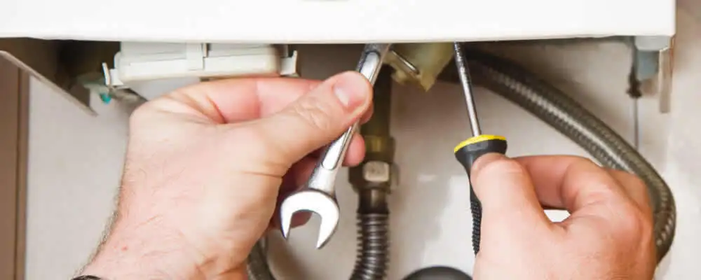 Boiler repair technician tightening pipe fittings and connections in Chattanooga, TN