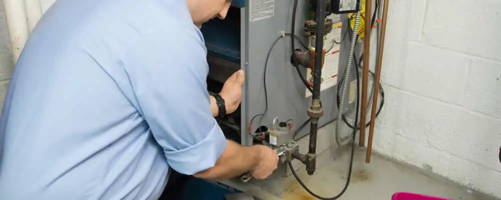 Furnace repair technician inspecting and servicing a home heating system in Chattanooga, TN