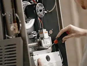 Furnace repair technician inspecting internal components and wiring in Chattanooga, TN