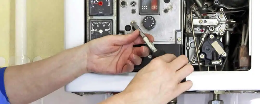 Heating repair technician adjusting boiler controls and components in Chattanooga, TN