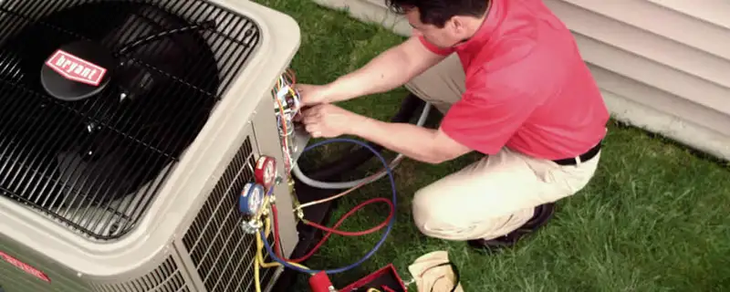 HVAC technician servicing an outdoor air conditioner unit in Chattanooga, TN