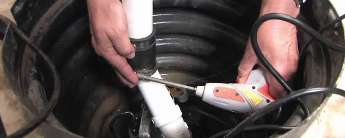 Sump pump installation technician connecting PVC discharge piping in Chattanooga, TN